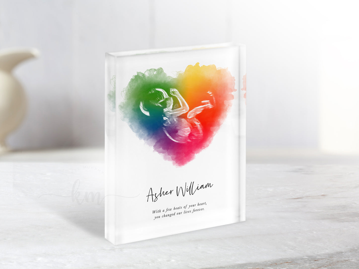 Close-up of rainbow baby keepsake with ultrasound image