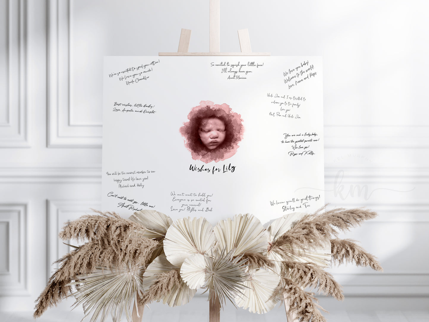 Holding watercolor ultrasound guestbook print with baby’s name

