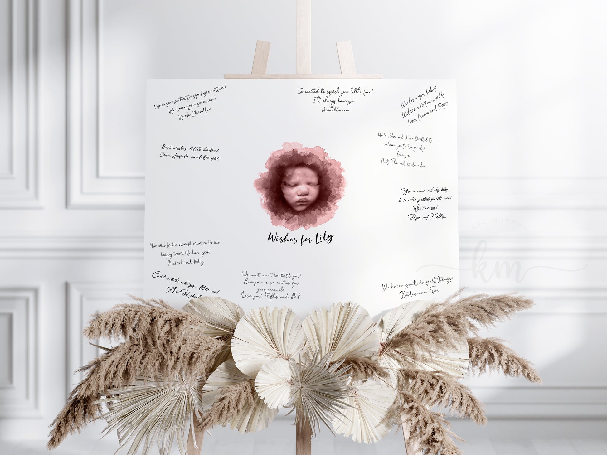 Holding watercolor ultrasound guestbook print with baby’s name

